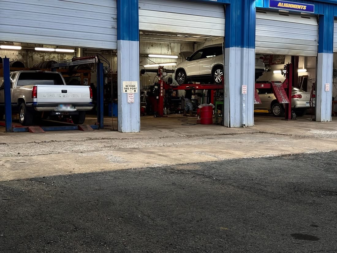 Vehicles on the lifts in the open alignment and brake bays at Garrett Automotive