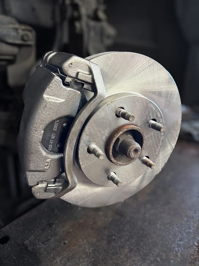 A brake caliper and new rotor on a hub