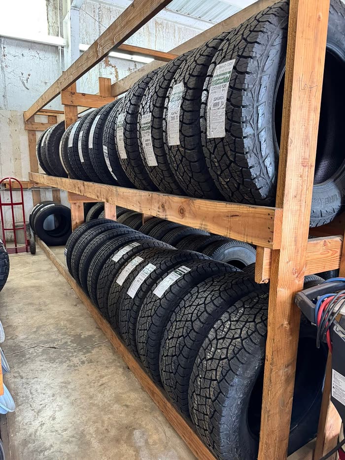 Rows of new tires on a wooden rack in the tire room